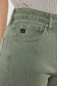 Close-up of green jeans with a brand logo on the pocket.