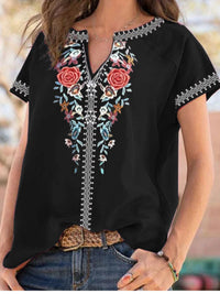 Black blouse with floral embroidery worn by a person outdoors