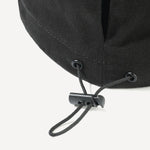 Close-up of a black cap with a chin strap on a white background