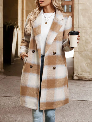 Person wearing a plaid coat holding a coffee cup outdoors.