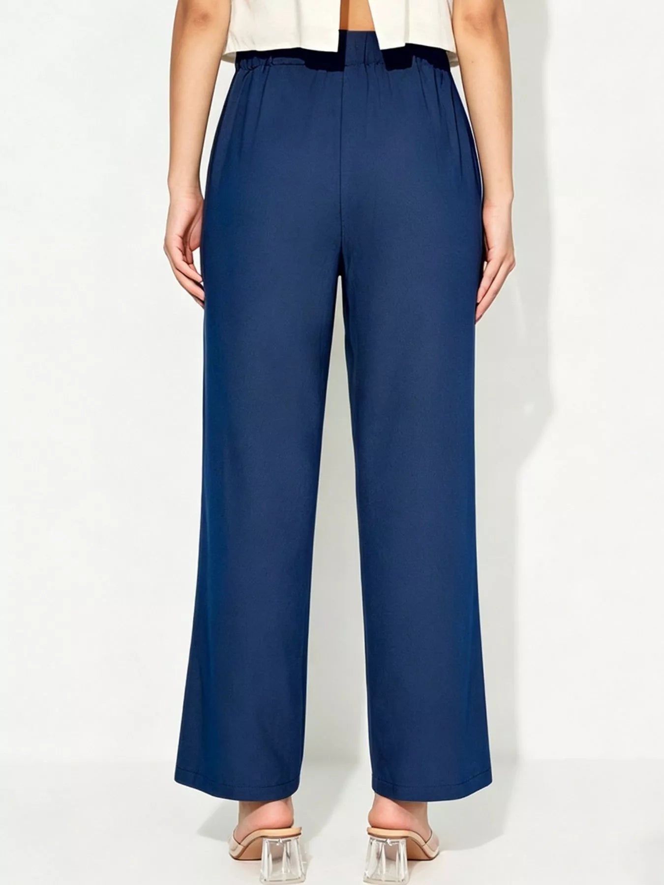 Person wearing navy blue pants on a white background