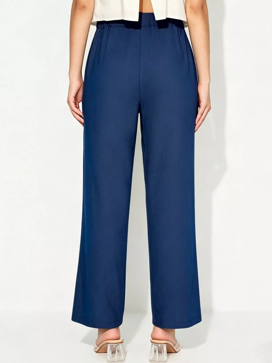 Person wearing navy blue pants on a white background