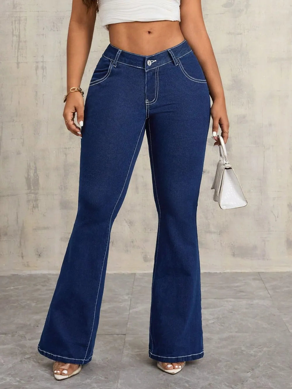 Person wearing blue flared jeans against a neutral background