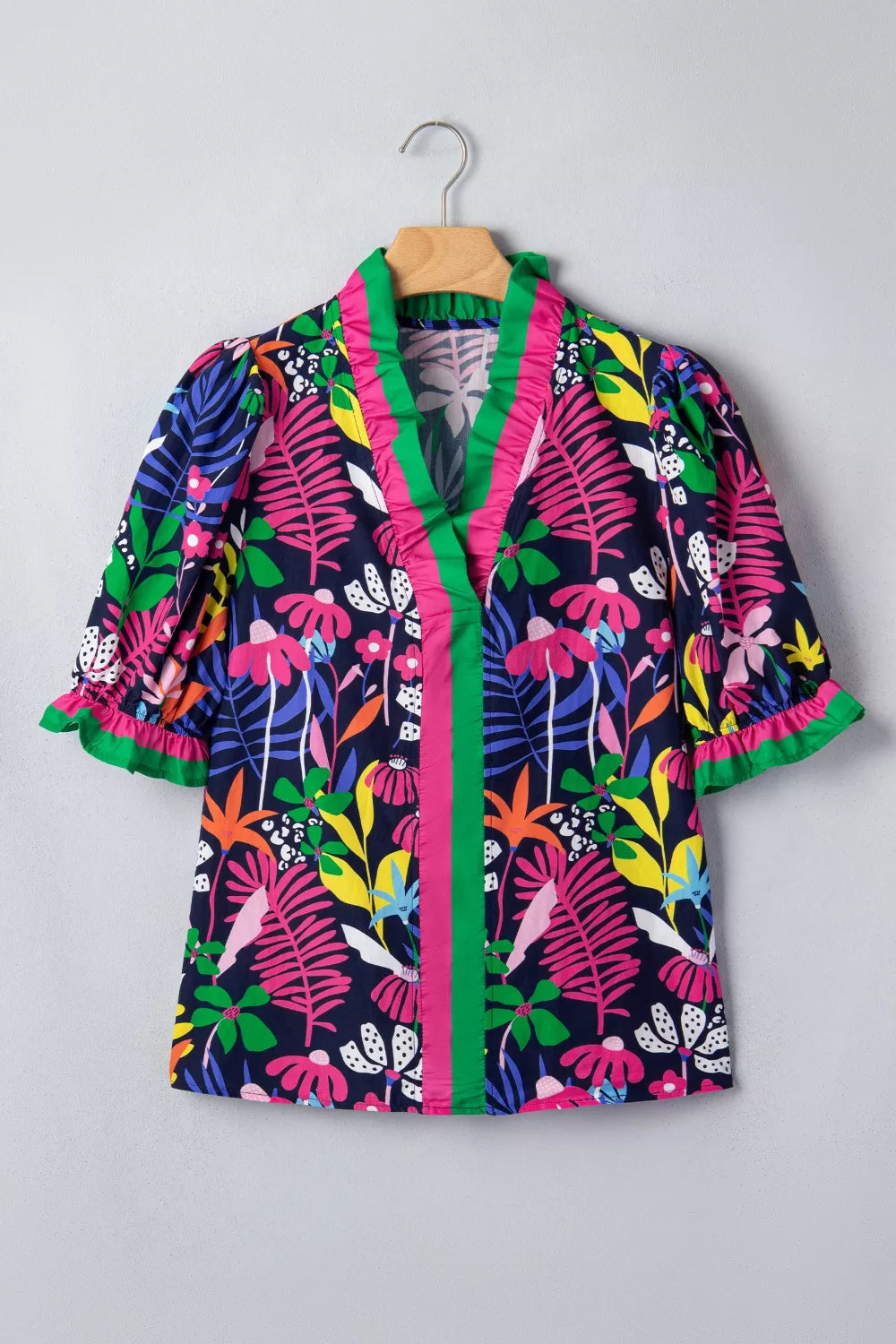 Colorful floral-patterned jacket on a hanger against a gray background