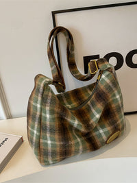 Plaid patterned handbag on a light surface with a blurred background