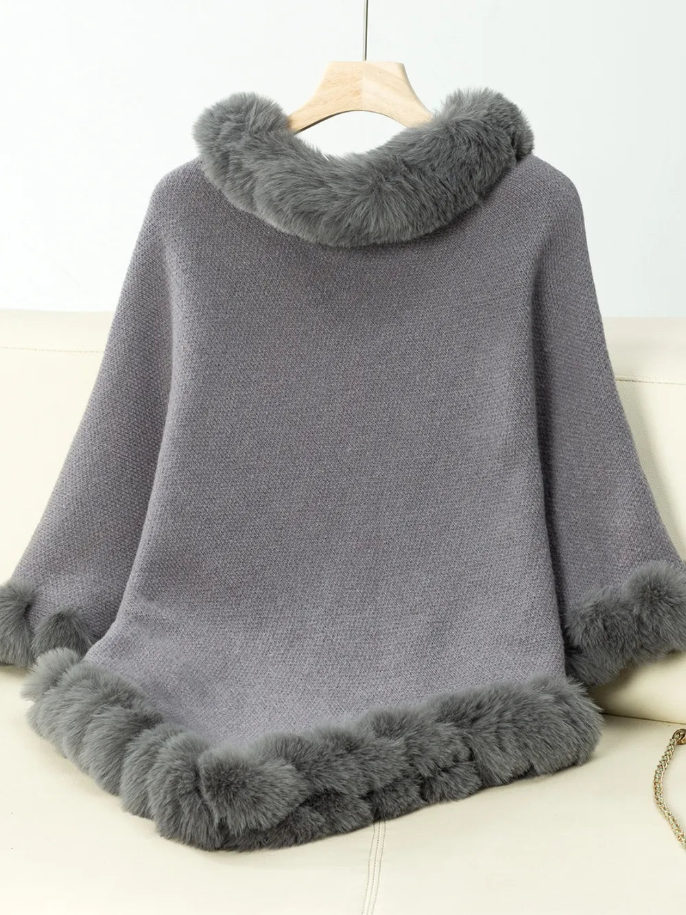 Gray poncho with fur trim on a white background