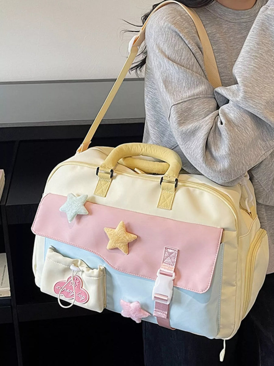 Pastel-colored bag with star decorations held by a person wearing a gray sweater.
