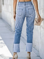 Person wearing light blue jeans with a blurred background