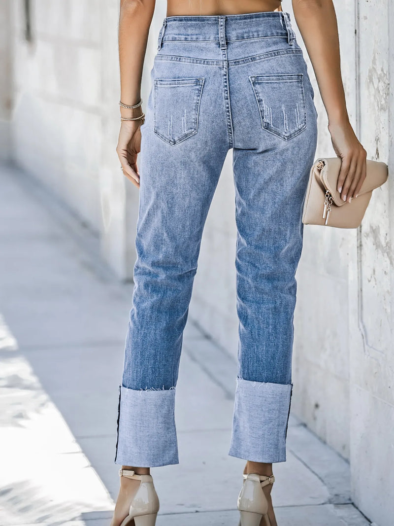 Person wearing light blue jeans with a blurred background