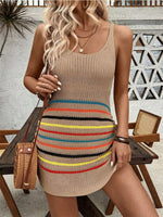 Woman wearing a beige knit dress with colorful stripes, standing outdoors.
