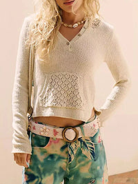 Person wearing a light-colored knitted sweater and tie-dye pants with a belt.