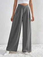Person wearing gray wide-leg pants against a white background