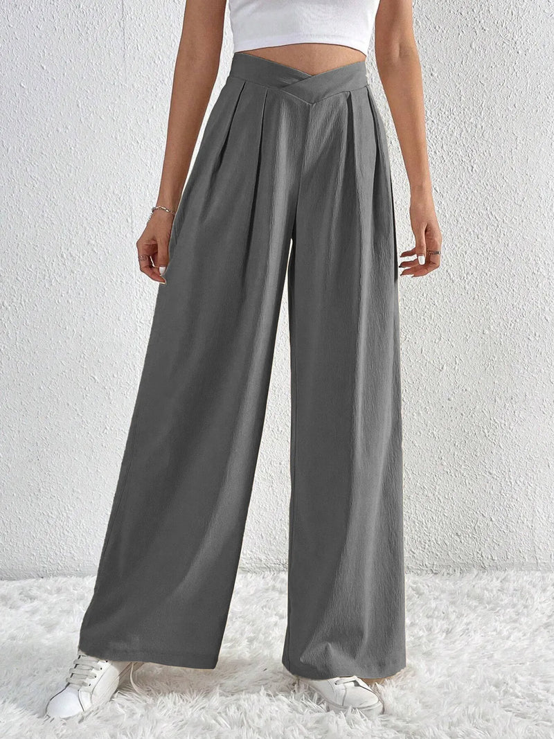 Person wearing gray wide-leg pants against a white background