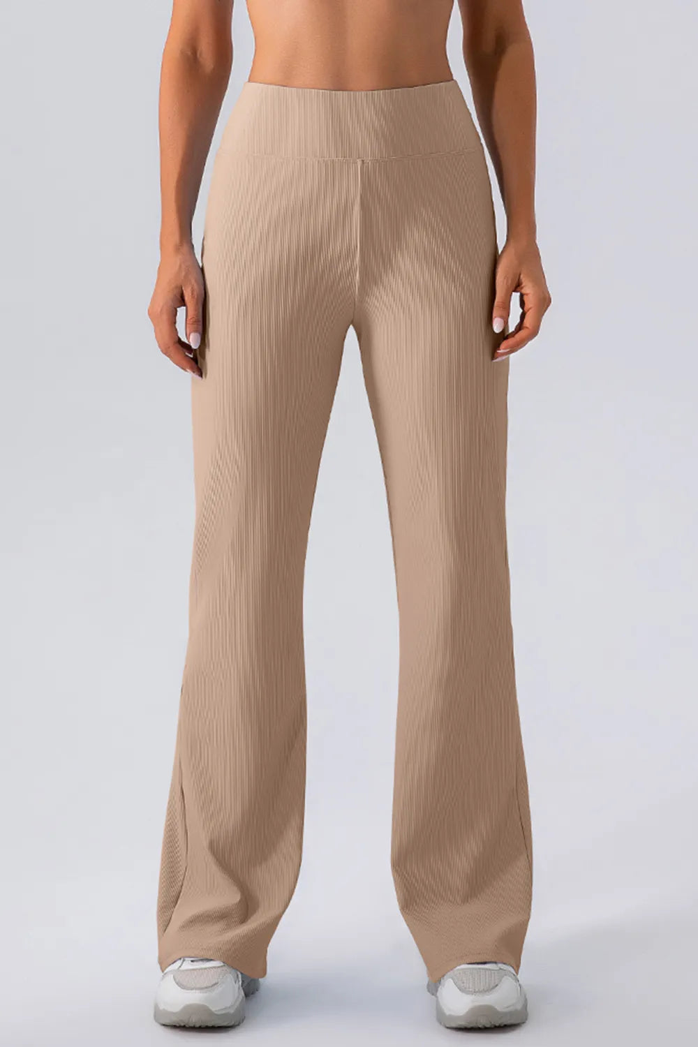 Beige ribbed pants worn by a person on a white background