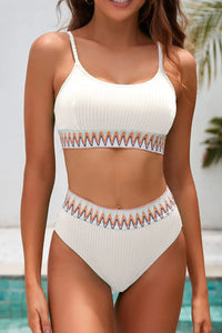 Woman wearing a white bikini with orange and blue patterns by a pool.