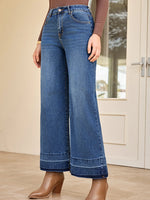 Person wearing blue wide-leg jeans indoors with a neutral background