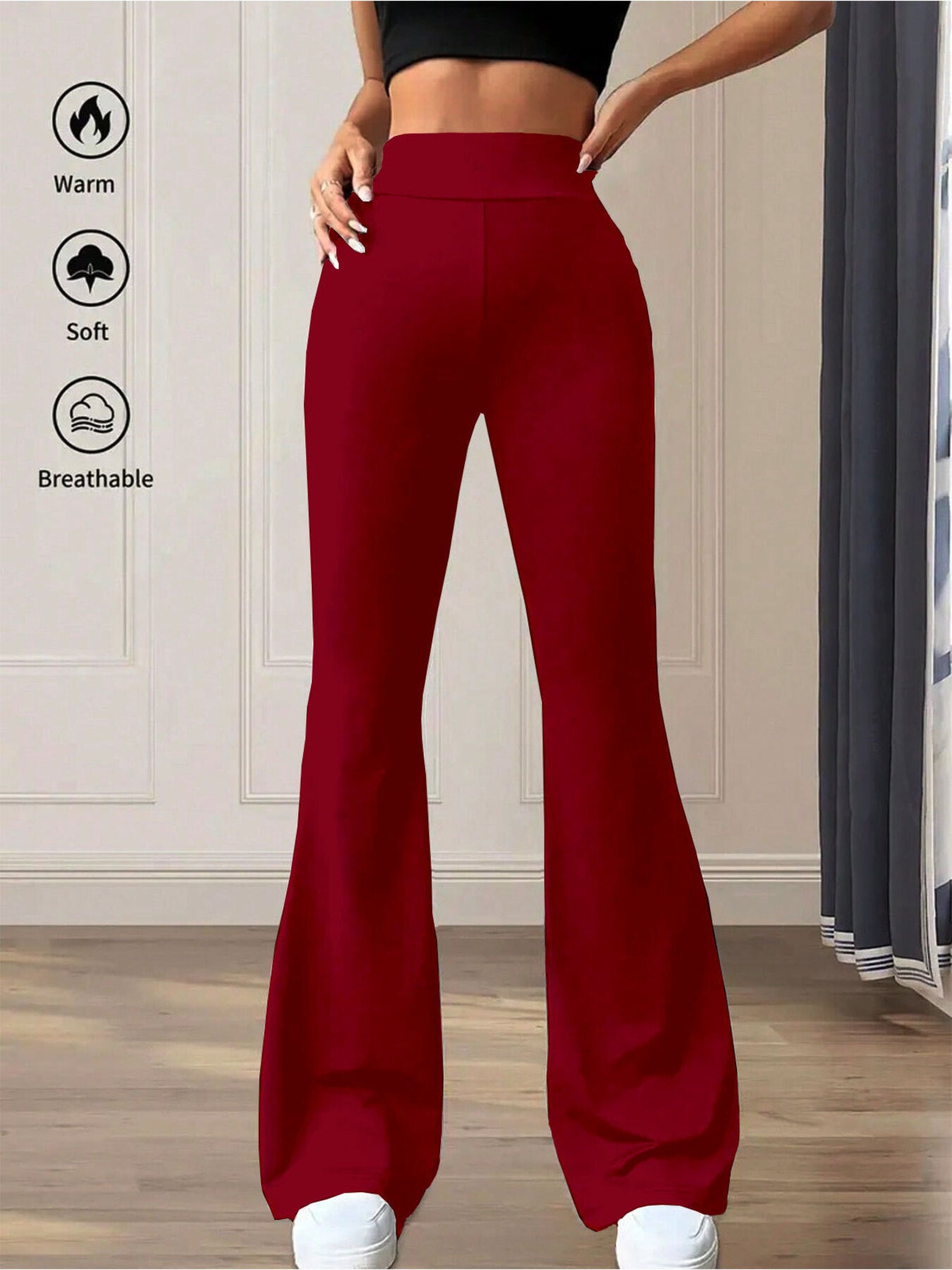 Red flared pants worn by a person with text icons indicating warmth, softness, and breathability on a neutral background.