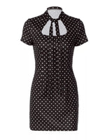 Black polka dot dress with a white collar on a white background