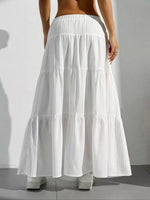 White tiered skirt worn by a person on a plain background