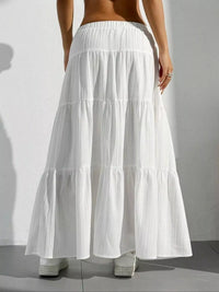 White tiered skirt worn by a person on a plain background
