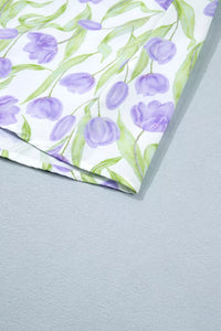 Floral-patterned paper with purple tulips and green leaves on a gray background