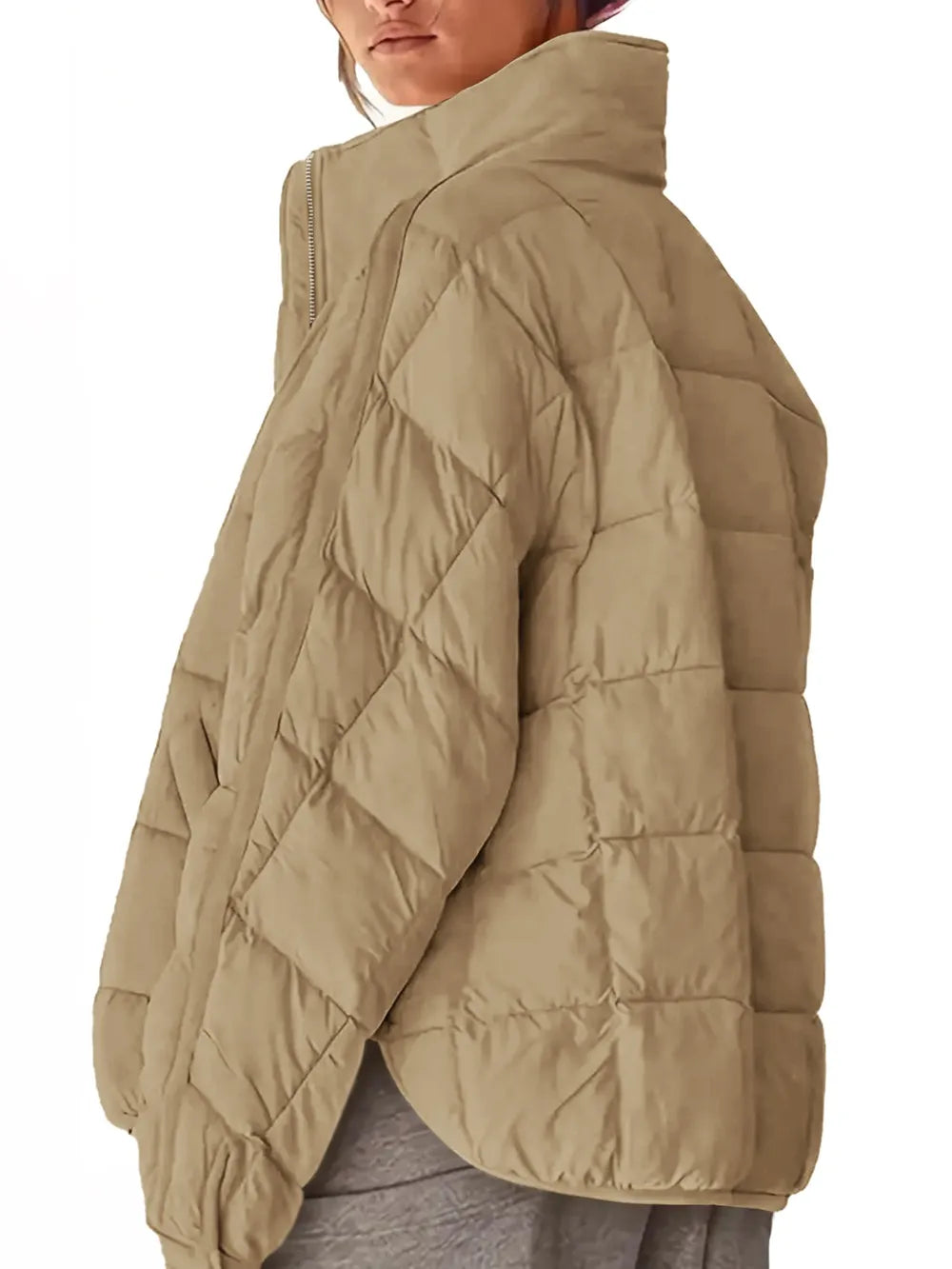Beige quilted jacket worn by a person on a white background