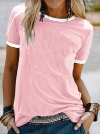 Person wearing a pink t-shirt with white trim outdoors