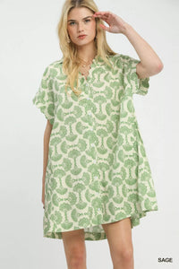 Woman wearing a green and white patterned dress on a white background