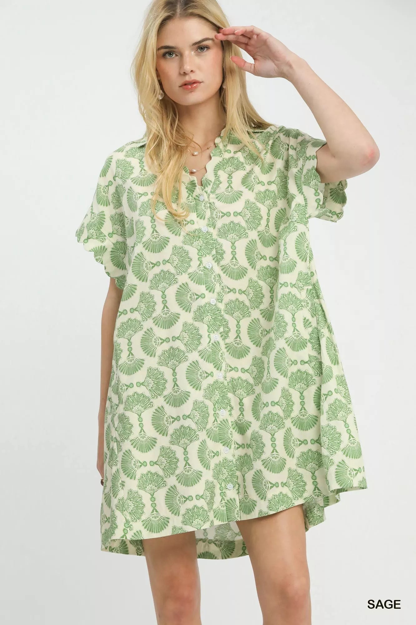 Woman wearing a green and white patterned dress on a white background