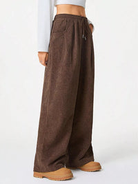 Brown wide-leg pants worn by a person on a white background