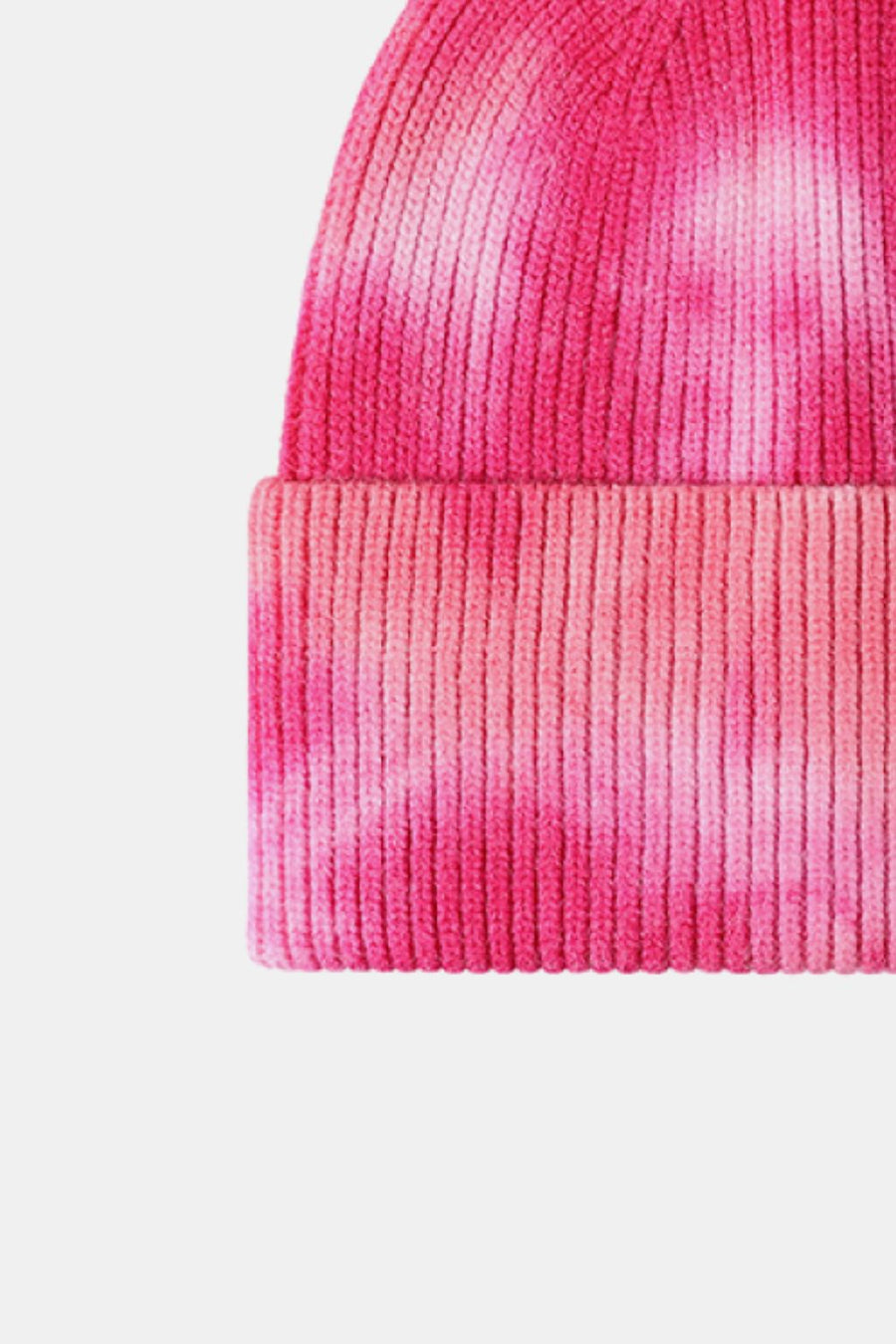 Close-up of a pink knit beanie with a gradient effect on a white background