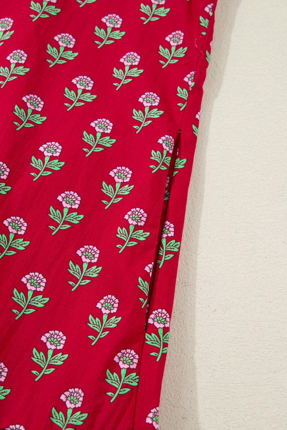 Red fabric with floral pattern on a beige background