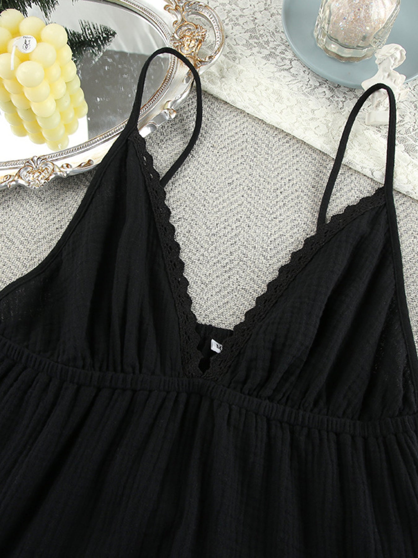 Black lace-trimmed nightgown on a textured surface with decorative elements.