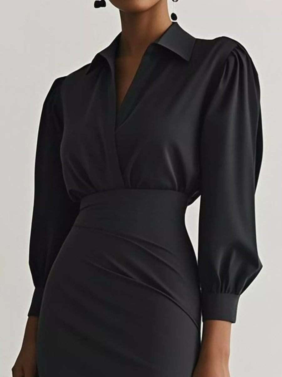 Black dress with puffed sleeves on a plain background