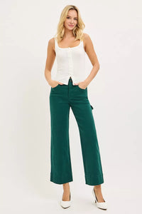 Woman wearing a white top and green pants on a white background