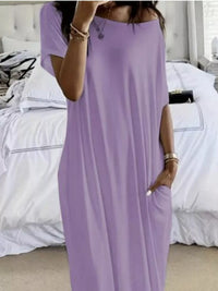 Person wearing a long purple dress in a bedroom setting