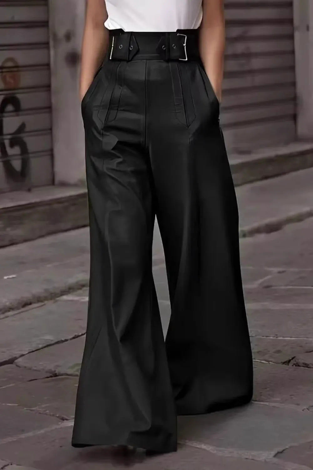 Person wearing black wide-leg pants with a belt in an urban setting