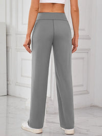 Person wearing gray high-waisted pants in a minimalistic setting