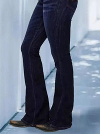 Navy blue corduroy bell-bottom pants worn by a person on a light blue floor.