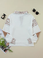 White blouse with leopard print sleeves on a beige background
