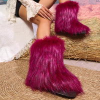 Person wearing bright pink furry boots sitting on a textured surface.