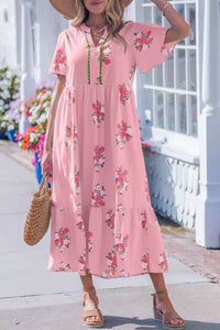 Woman wearing a pink floral dress with a white background