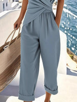 Person wearing a light blue jumpsuit by a waterfront.