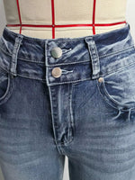 Close-up of blue jeans with a checkered shirt in the background
