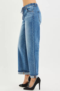 Blue jeans worn by a person on a white background