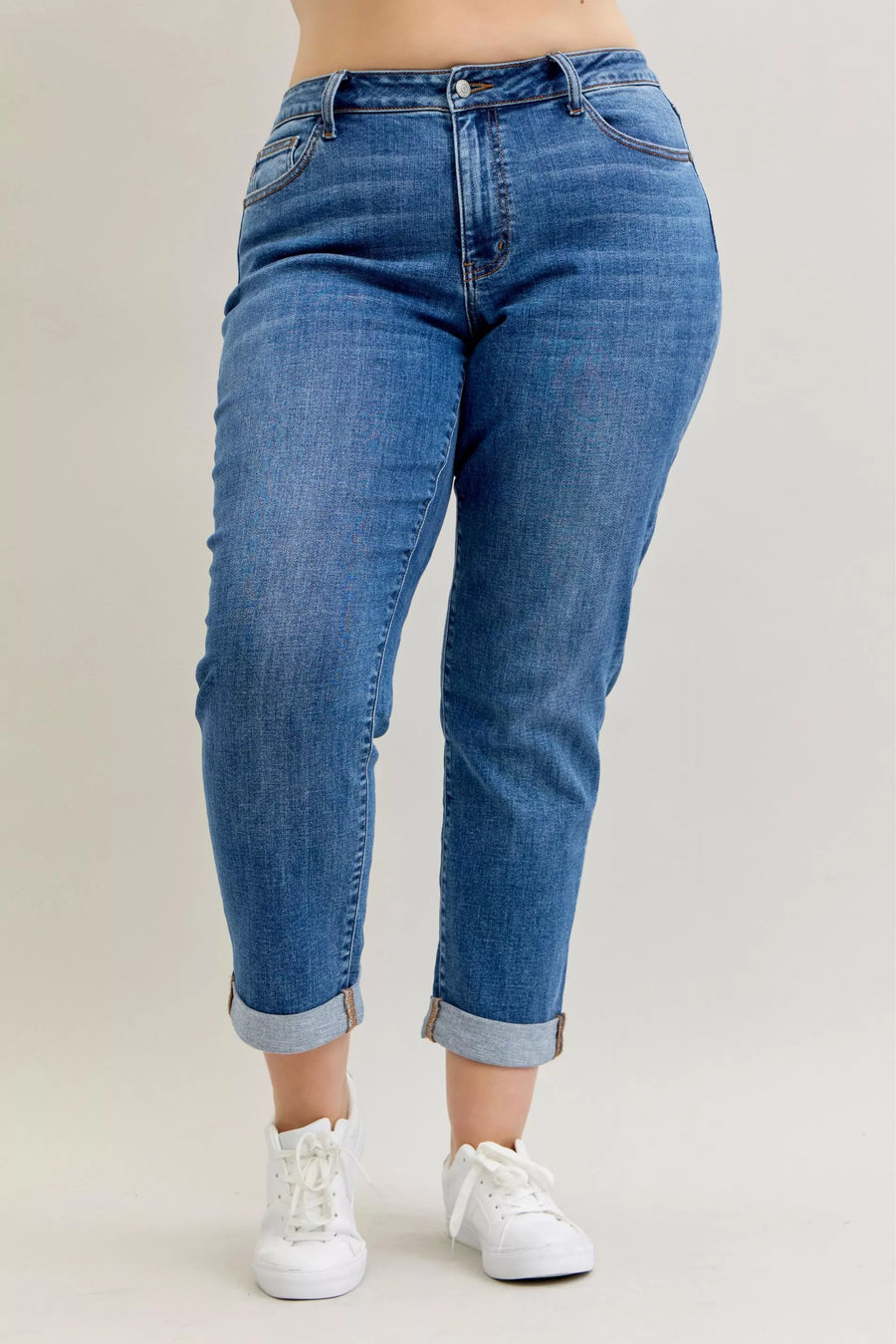 Blue jeans worn by a person on a plain background