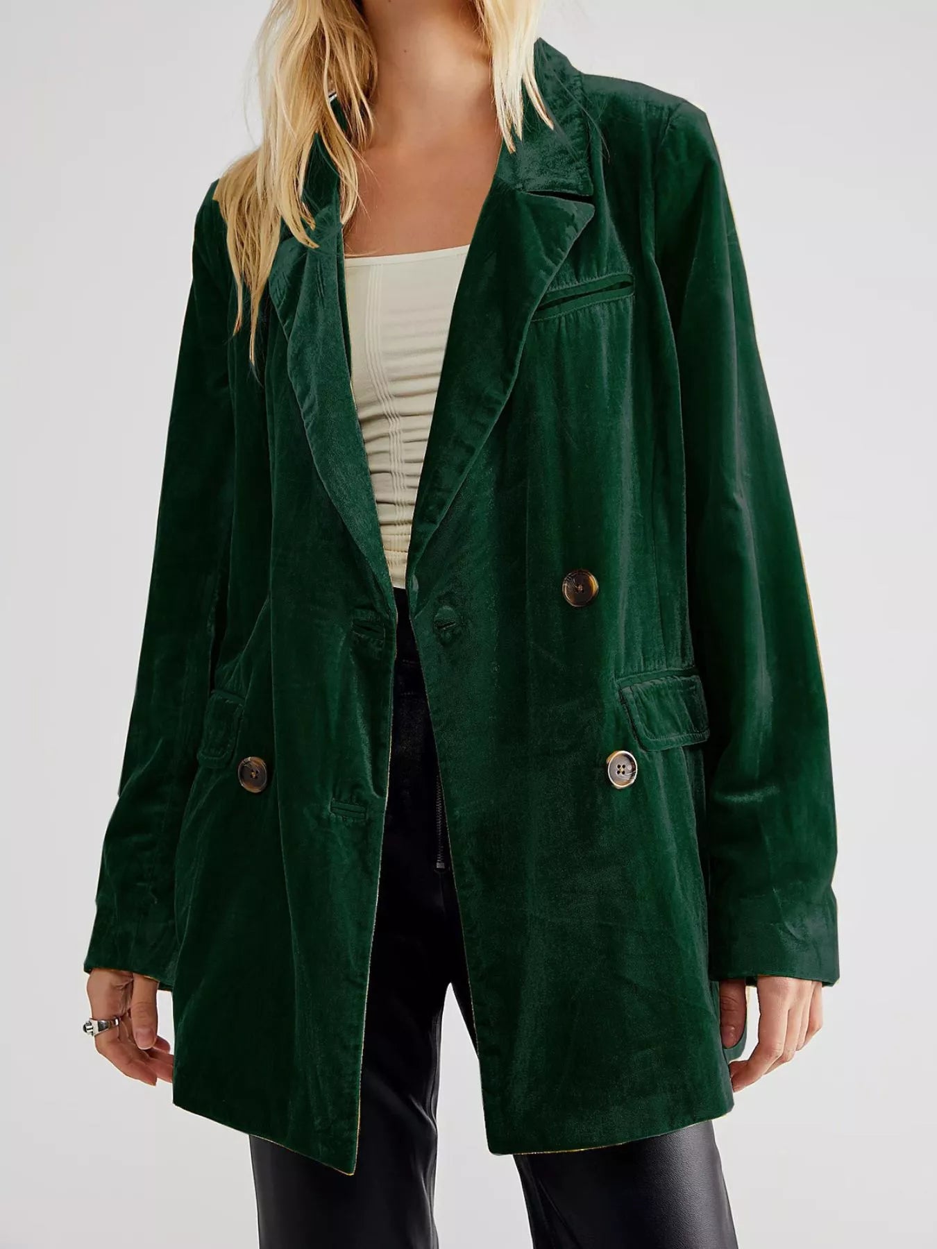 Green coat worn by a person on a plain background