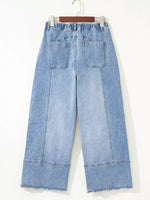 Light blue denim wide-leg pants on a hanger against a white background