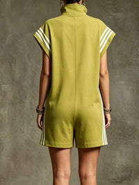 Person wearing a green dress with white stripes on a textured gray background