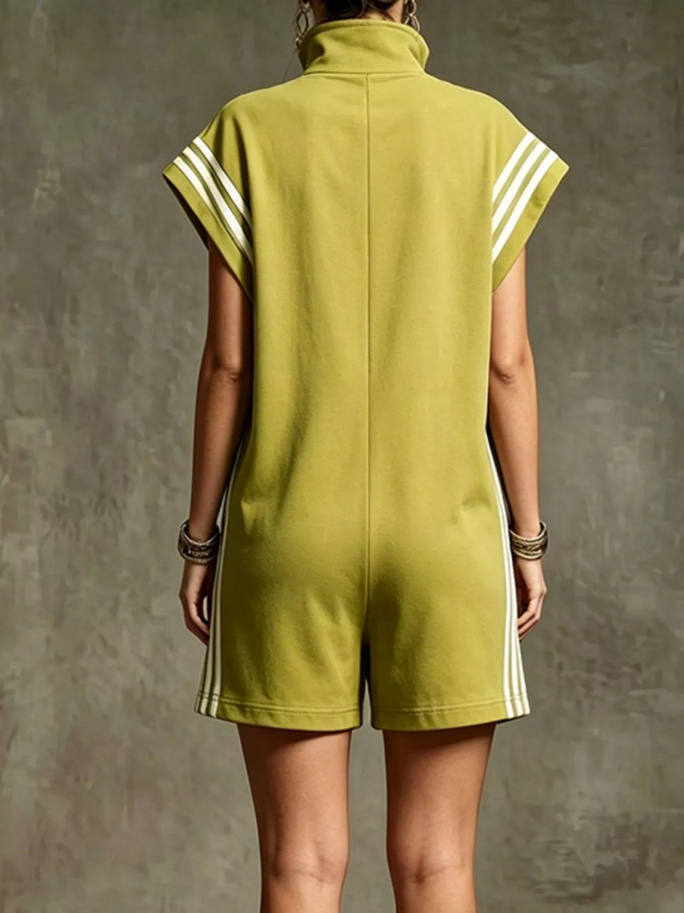 Person wearing a green dress with white stripes on a textured gray background